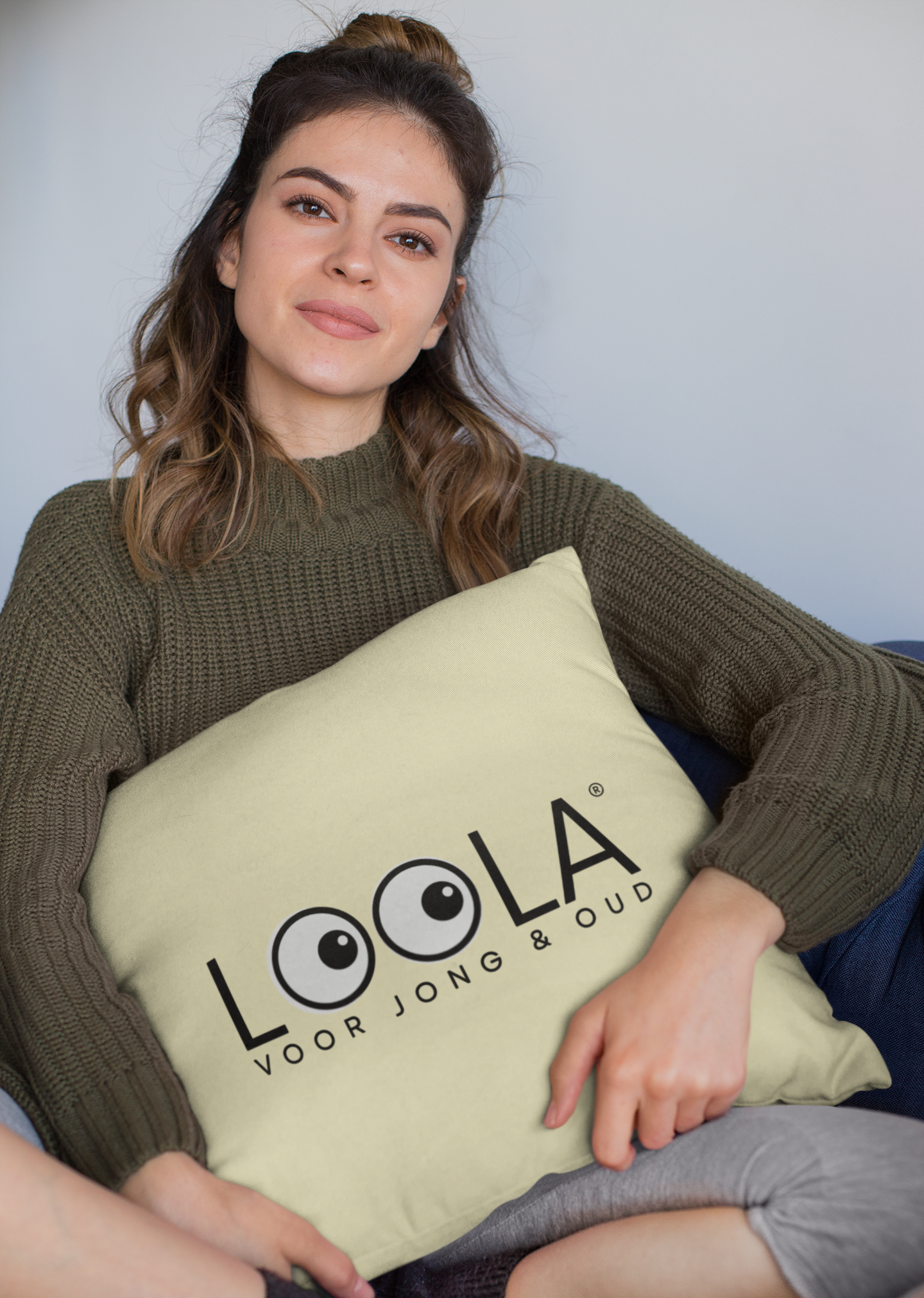 mockup-of-a-woman-holding-a-square-pillow-while-sitting-23577.png
